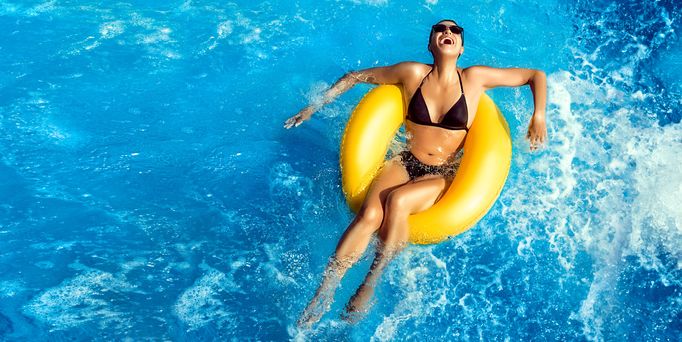 Frau im Pool auf einem Schwimmreifen Frühbucher