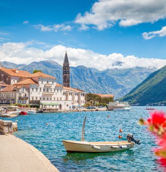 Schöner See mit Boot, Dorf und Bergen 