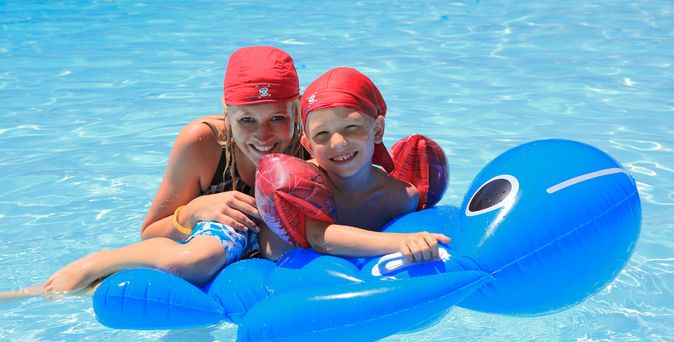 Kinderanimation. Kind mit Dame im Pool und Luftmatratze 