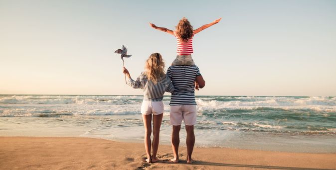 Familienurlaub. Familie steht am Meer am Abend 